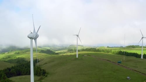 Wind Turbines Turning on Grassy Green Hills