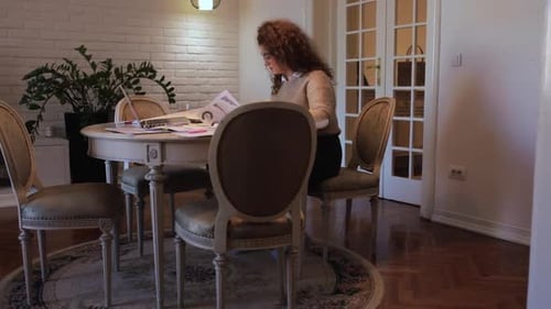 Young Woman Analyzes Data Charts at Home