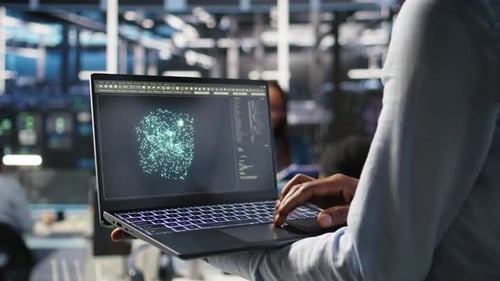Close Up of Data Center Worker Using Laptop to Interpret AI Data Analytics