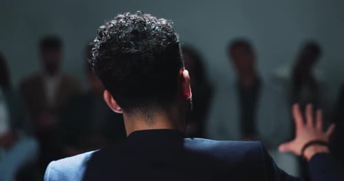 Speaker Addressing Audience in Dark Room