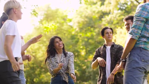 Leisure, Fun And Entertainment Concept - Happy Friends Dancing At Summer Party In Park