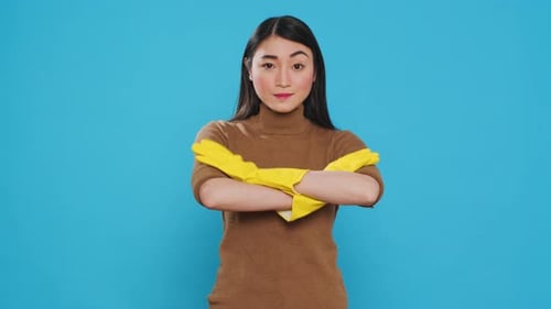 Woman with Yellow Gloves Stands Before Blue Background
