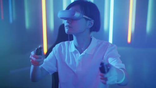 East Asian Pro Gamer Wearing Virtual Reality Headset Plays in a Online Video Game, Gesturing. Cool