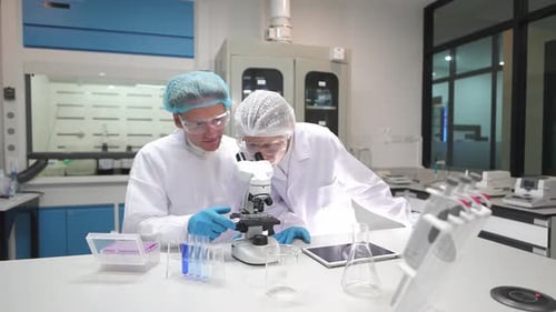 Researchers Working with Microscope in Modern Laboratory