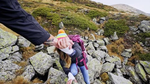 Man Helping Woman During Mountain Hike