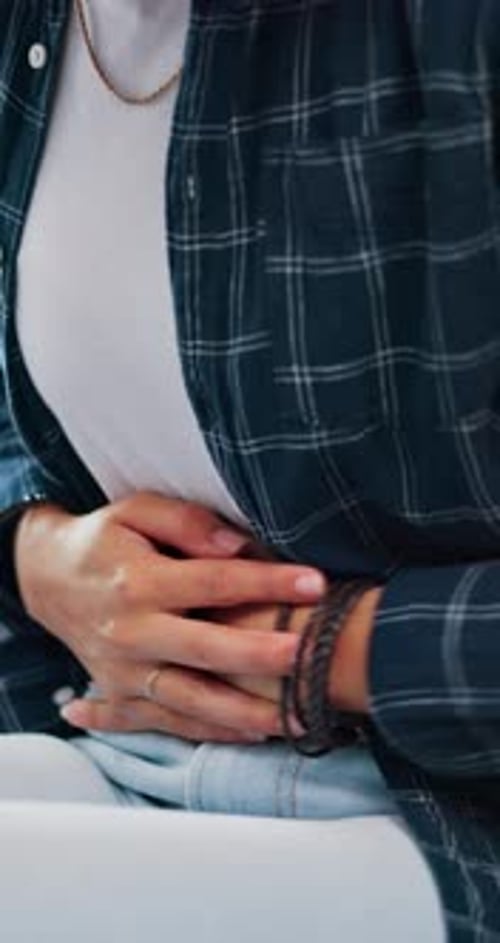 Woman, hands and stomach ache in home with menstruation cramps, bowel inflammation