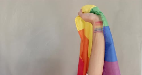 Hand Holding a Rainbow Pride Flag