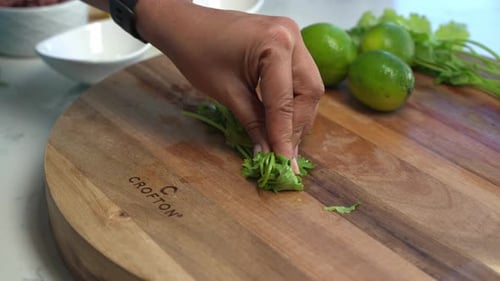 Person Chopping Cilantro on Wooden Cutting Board