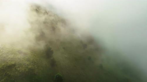 Sunlight Gently Pierces the Mist Over Vibrant Green Slopes Sunlit Mist Over Green Mountain Flanks