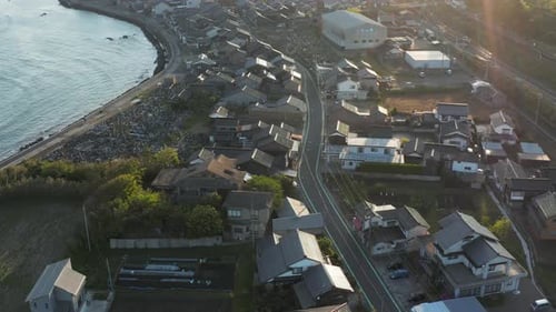 Sunrise over Sea of Japan and small Mikuriya Town, Tottori, Aerial Tilt Shot