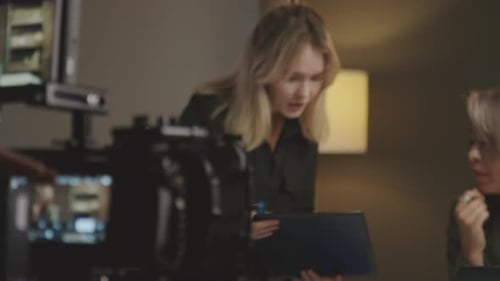 Producer Talking to Production Assistant before Filming in Studio