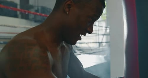 Cinematic shot of a professional young muscular shirtless african man is tired after a practicing