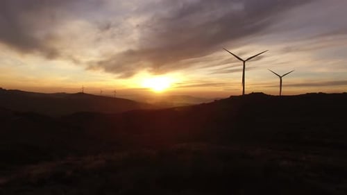 Malerische Luftaufnahme des Windturbinenparks bei Sonnenuntergang. Hochwertiges 4K-Filmmaterial