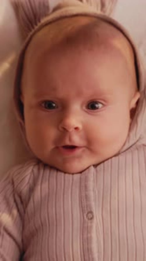 Un enfant en sweat à capuche regarde un bébé chéri et brillant dans une tenue confortable à capuche regarde avec émerveillement avec douceur