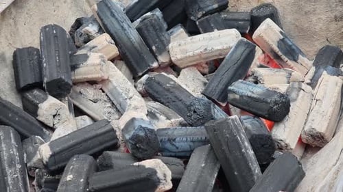 A close-up view of charcoals piled together, showcasing their texture and color variations