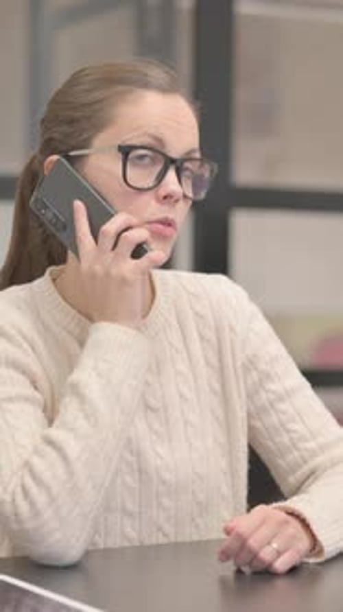 Young Woman Talking on phone in Office