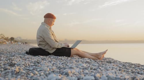 Digital Nomad of the Millennial Generation is Working on a Laptop on the Beach