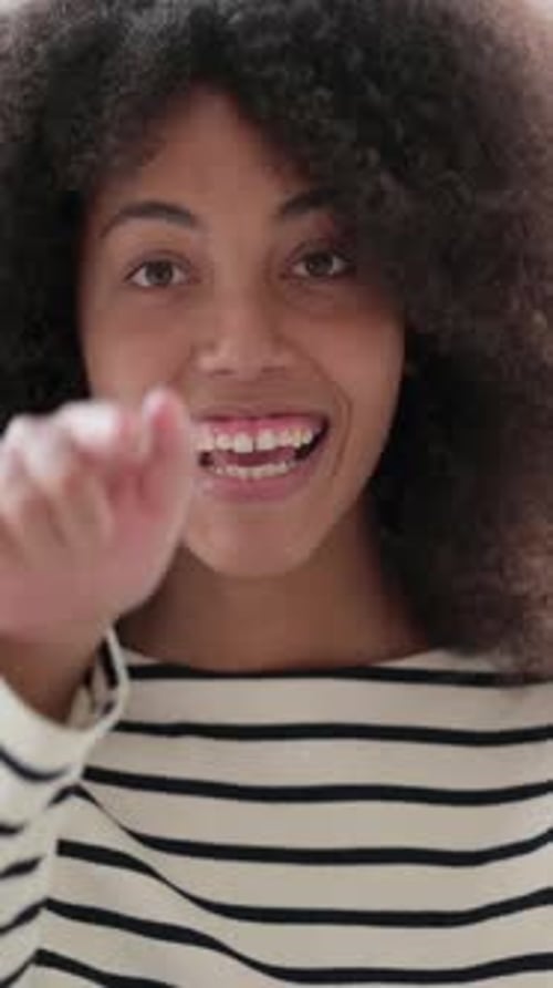 Hermosa mujer africana con un vídeo vertical que señala y invita