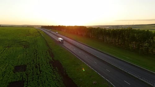 Highway in the Rays of the Setting Sun and a Moving Truck with a Semitrailer