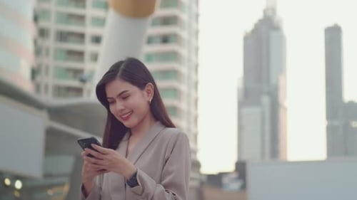 A young beautiful businesswoman is using Smart phone in Modern city