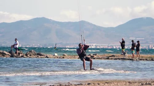 Sportsman practicing kite surf sport at the beach on a windy day at the Spanish coasts