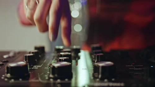 DJ utilisant une table de mixage manuelle contrôlant de manière experte le rythme d'une boîte de nuit, gros plan, femme, mixage