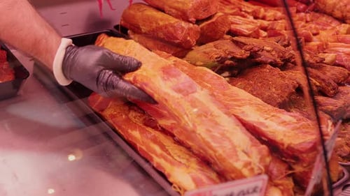 Close up shot of dried and smoked meat production on display in a shop.