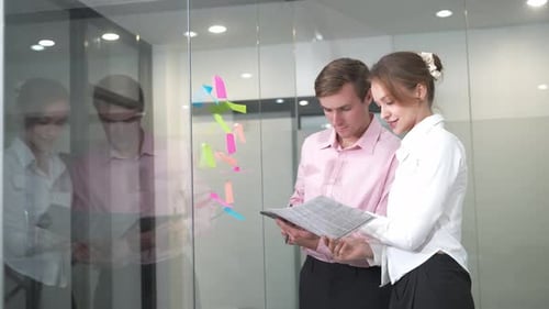 Man and woman collaborate at work with notes