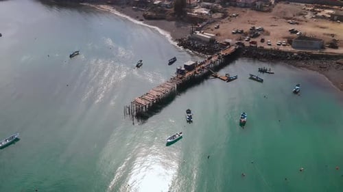Aerial of Cedros Island pier and docked fishing boats under warm morning light