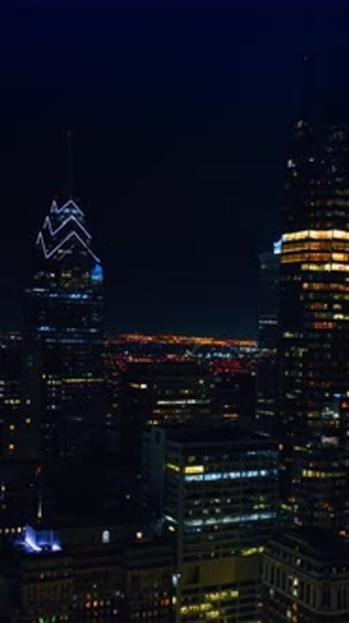 Rising along the skyscrapers with lights on in the windows. Night view of Philadelphia
