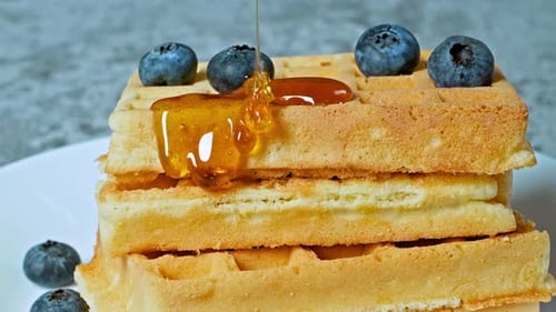 Close Up of Waffles Being Drizzled with Honey