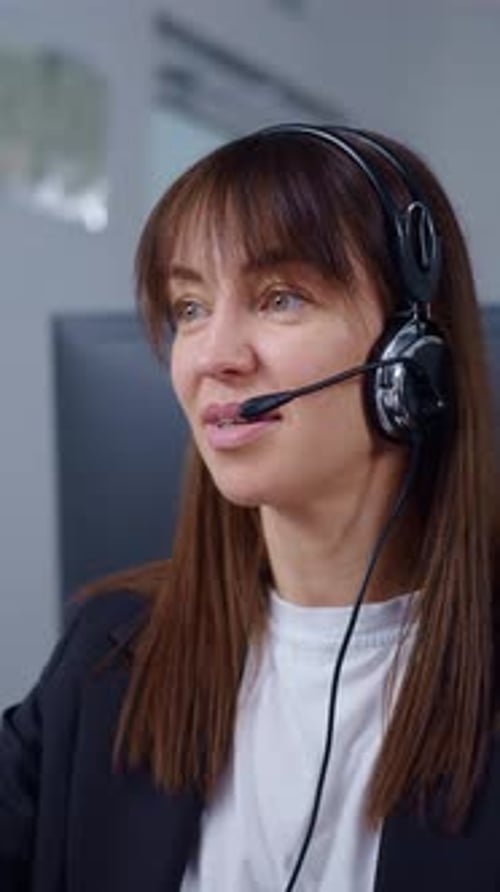 Konzentrierte Call-Center-Agentin mit Headset und Mikrofon bietet Kundensupport aus der Ferne