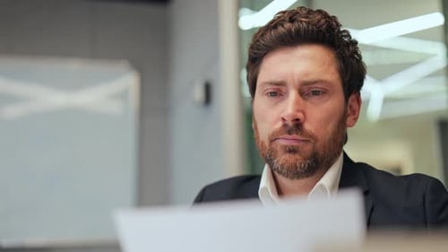 Man in Suit Contemplates Decision While Reading Document
