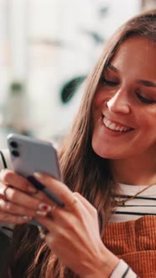 Smiling Woman Checks Her Phone Indoors