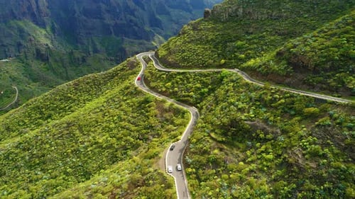 Cars Driving on New Asphalt Winding Road in Spring Green Mountain Nature