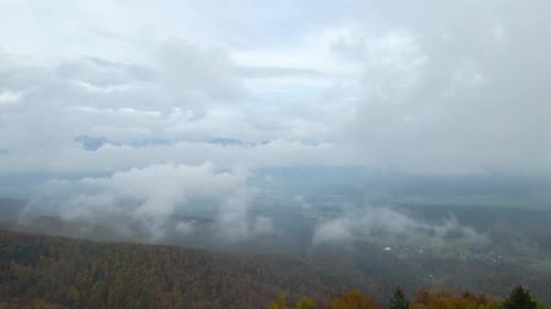 Backward moving aerial showing historic ancient church built on the peak of mountain range.