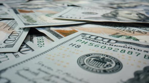Large Heap of Paper Hundred Dollar Bills Lying on Surface Rotating Close