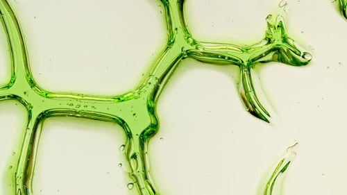 Transparent Green Cosmetic Gel Fluid With Molecule Bubbles and Oil on White Background Macro Shot