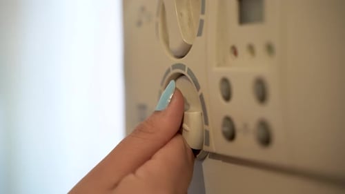 Young woman turning on the boiler 4K