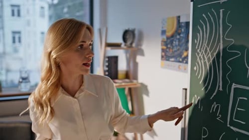 College Professor Explaining Formulas on Chalkboard Closeup Lady Educator