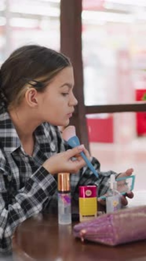 Teen Girl Applying Makeup at Table Indoors