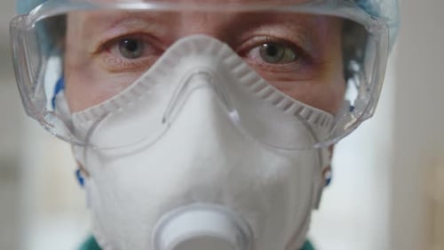 Porträt einer Laborärztin mit Schutzmaske und Brille