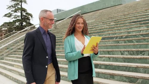 Businesspeople Walking and Discussing Using Tablet