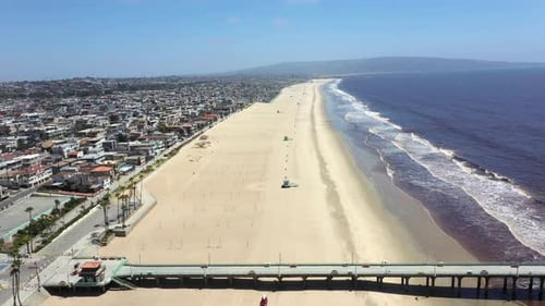 Manhattan Beach Pier and the Pacific Ocean near Los Angeles California - aerial pullback. covid beac