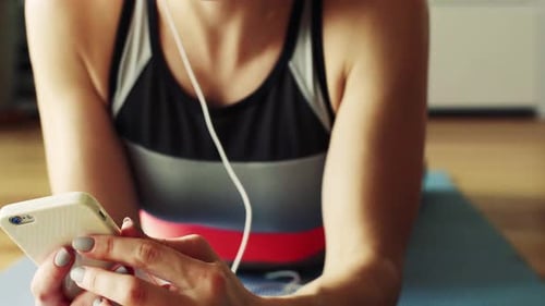 Woman Lying on Yoga Mat Listening to Music