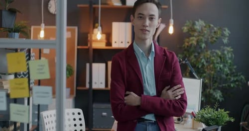 Slow Motion Portrait of Confident Young Businessman Standing in Office with Arms Crossed Looking at