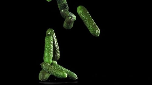 Cucumbers Fall on the Table on a Black Background Filmed on a Highspeed Camera at 1000 Fps