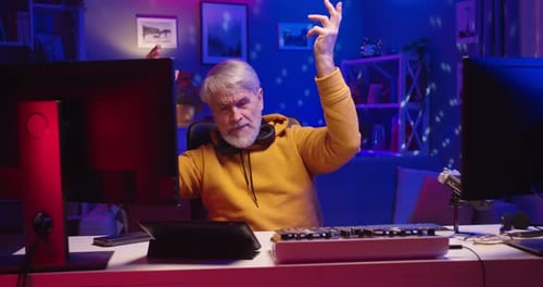 Enthusiastic Senior Man Dances While Mixing Music