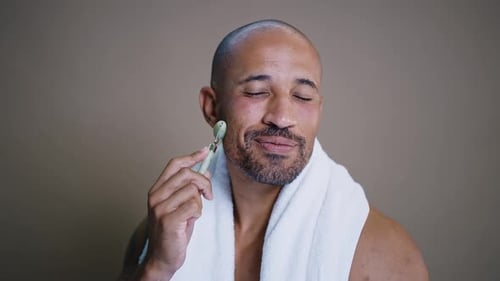 Man Giving Himself a Facial Massage with Roller