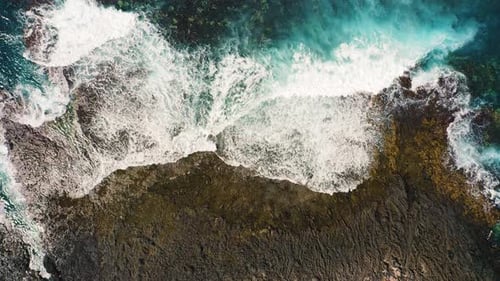 Waves Crashing and Foaming on Empty Rocky Tropical Beach with Big Volcanic Formations Stones